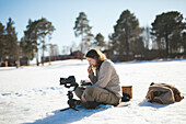 Fotograf sitzt im Schnee und entspannt sich