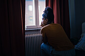 Pensive young woman sitting at home