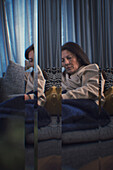 Digitales Komposit einer nachdenklichen Frau, die zu Hause sitzt