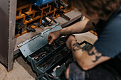 Schmied sucht nach Werkzeugen im Werkzeugkasten