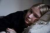 Porträt einer nachdenklichen Teenagerin im Bett liegend