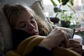 Pensive teenage girl lying in bed