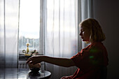 Pensive teenage girl sitting at table