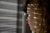 Close-up of pensive teenage girl looking through window