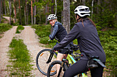 View of women cycling in forest