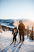 Vater und Kind fahren zusammen Ski