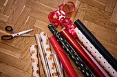 Various Christmas wrapping papers and scissors on floor