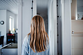 Rear view of girl standing at home