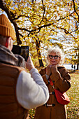 Man photographing woman with cell phone