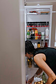 Woman standing in front of open fridge