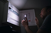 Electrician checking electrical cabinet at night