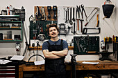 Schmied posiert in seiner Werkstatt