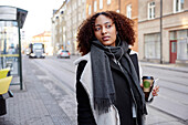 Young woman walking, city street in background