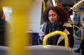 Junge Frau telefoniert mit Handy im Zug