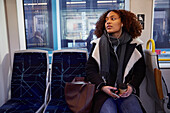 Junge Frau hört Musik im Zug