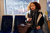 Young woman listening music in train