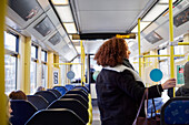 Young woman standing in bus