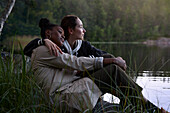 Junge Frauen sitzen zusammen am See