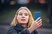 Junge Frau macht Selfie im Freien