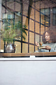 Junge Frau isst in einem Café