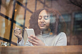 Junge Frau mit Handy in einem Café