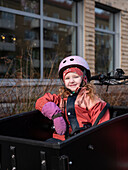 Lächelndes Mädchen auf einem Lastenfahrrad
