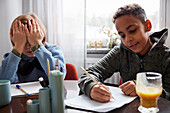 Zwei Jungen machen Hausaufgaben am Esstisch