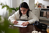 Girl doing homework at dining table