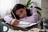Girl doing homework at dining table