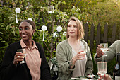 Lächelnde Frauen feiern eine Party im Garten