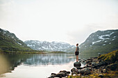 Woman standing at lake in mountains