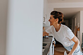 Smiling woman in kitchen looking away