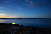 Blick auf beleuchtetes Zelt am Meer