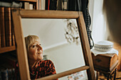 Ältere Frau schaut in den Spiegel