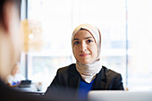 Woman in headscarf sitting in cafe