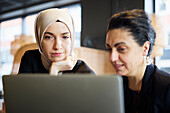 Businesswomen using digital tablet in cafe