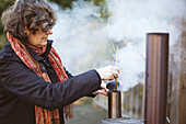 Woman starting fire in outdoor oven