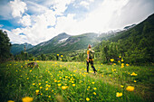 Woman hiking through meadow