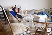 Woman on sofa using cell phone