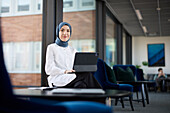 Geschäftsfrau im Hidschab benutzt digitales Tablet im Büro