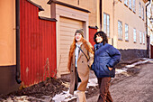 Smiling young women walking in street