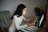 Girl doing homework with laptop