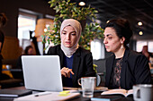 Businesswomen using laptop in cafe