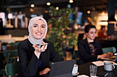 Businesswoman using cell phone in cafe