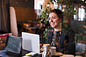 Lächelnde Geschäftsfrau mit Laptop in einem Café