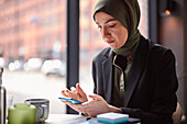 Frau mit Handy in einem Café