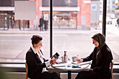 Lächelnde Frauen im Café sitzend