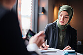 Woman in headscarf sitting in cafe