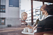 Blick durch das Fenster auf Frauen im Café