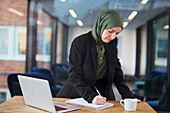 Frau im Büro macht Notizen